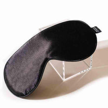 Black Sleeping Eye Mask with adjustable elastic strap on glass box