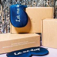 Silk 'Let Me Sleep' Eye Masks hanging on Moonlit Skincare boxes with New Years Eve backdrop