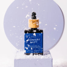 Purple Midnight Shift Overnight Facial Oil bottle with wooden detail and rubber dropper with snow