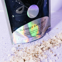 Slumber Bath Salts in packaging with salts scattered in front containing lavender, geranium, and frankincense essential oils to induce relaxing sleep