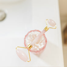 Moonlit Skincare Rose Quartz Facial Roller Tool on top of a cup on the counter from bird's eye view