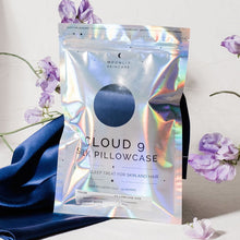 'Cloud 9' Night Sky Navy Blue Silk Pillowcase in iridescent packaging standing upright in front of silk pillowcase draped in background