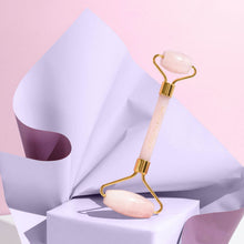 Moonlit Skincare Rose Quartz Facial Roller Tool on purple box with purple paper in the back on pink background